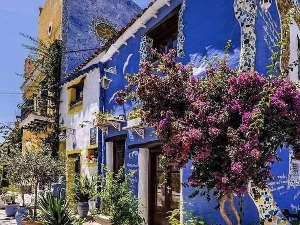 Facciata blu con mosaici e fiori a Borgo Parrini